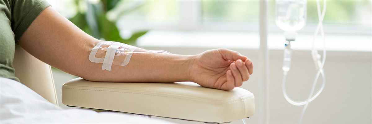 Brazo de un paciente en reposo con una v&iacute;a intravenosa colocada durante una sesi&oacute;n de sueroterapia