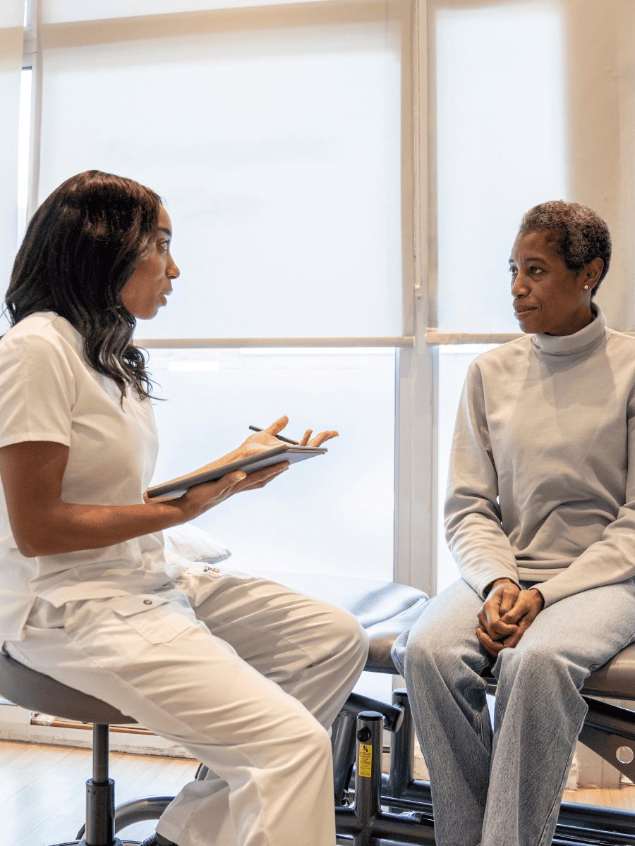 Doctora conversando con una paciente durante una valoraci&oacute;n m&eacute;dica integral
